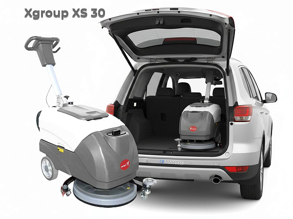 Поломоечная машина XGroup XS30 со сложенной ручкой загружается в багажник небольшого семейного автомобиля. Машина идеально помещается.