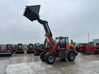Телескопический погрузчик QUADTRAC WL100T EVO с ковшом 1,5 м³ на строительной площадке.