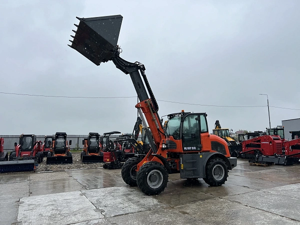 Телескопический погрузчик QUADTRAC WL100T EVO с ковшом 1,5 м³ на строительной площадке.